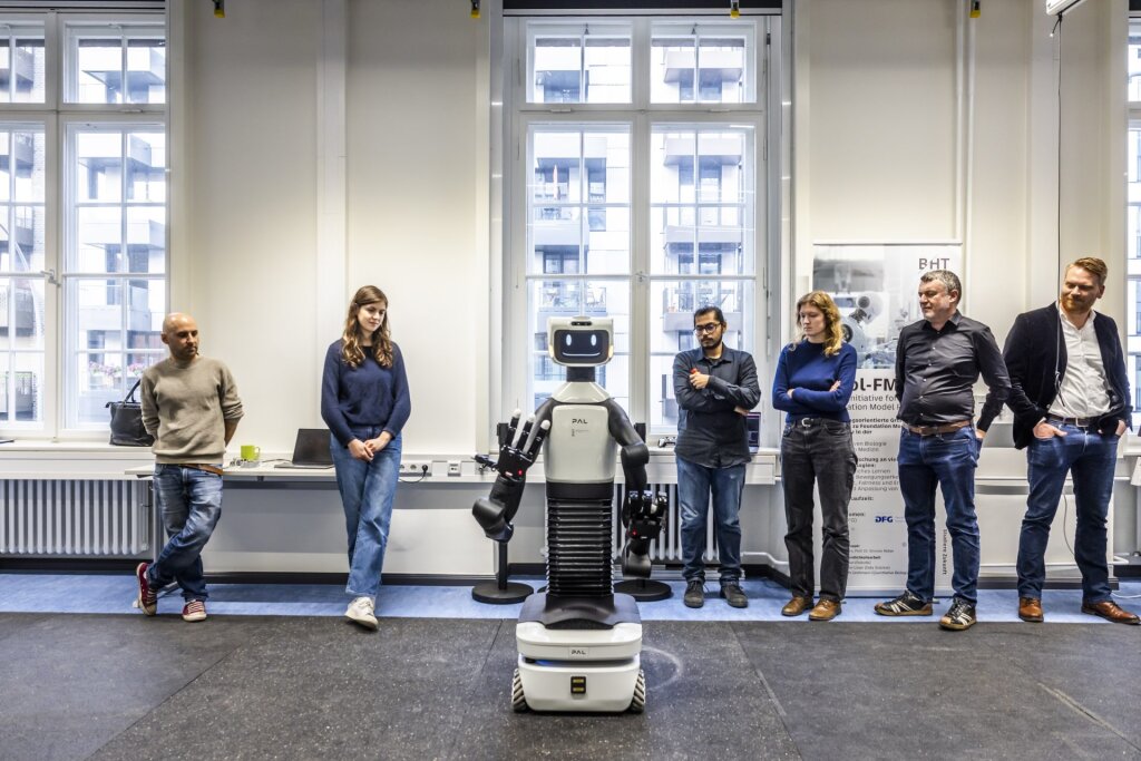 Group picture with humanoid robot in the center